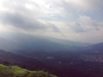 Scenic view of mountains against cloudy sky