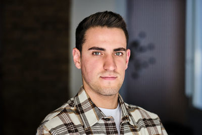 Portrait if a young man at home looking at camera.