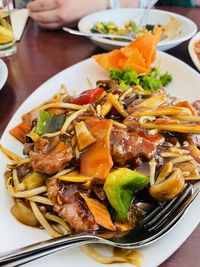 Close-up of chinese food in plate on table, beef with vegetables in a thick sauce