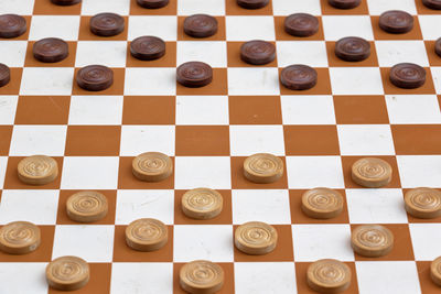 High angle view of game pieces on chess board