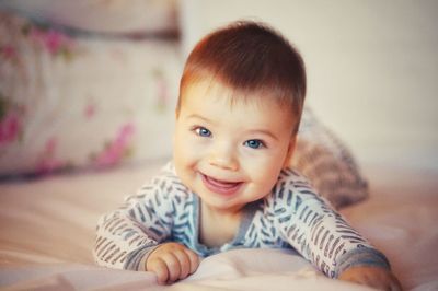 Portrait of cute baby boy lying on bed