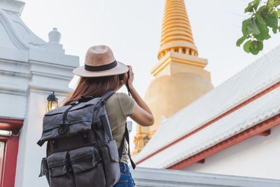 Rear view of woman standing at temple