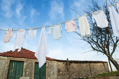Low angle view of clothes hanging on clothesline against building
