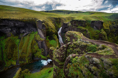 Scenic view of waterfall against sky