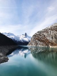 Scenic view of lake and snowcapped mountains against sky