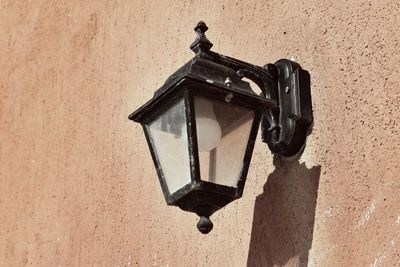 Low angle view of lantern hanging on wall