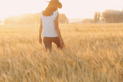 Rear view of woman standing on field