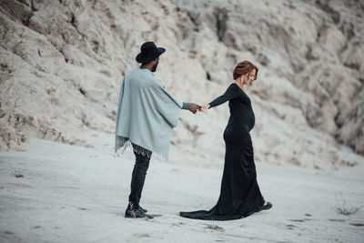 Rear view of couple standing on land