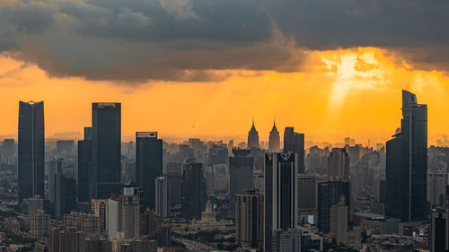 Skyscrapers in city against sky during sunset