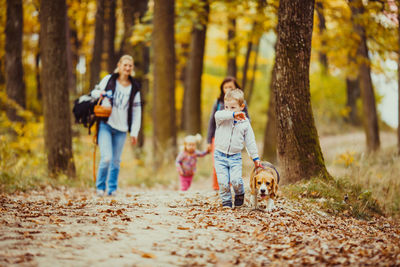 Woman and dog in forest during autumn