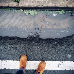 Low section of person standing on road