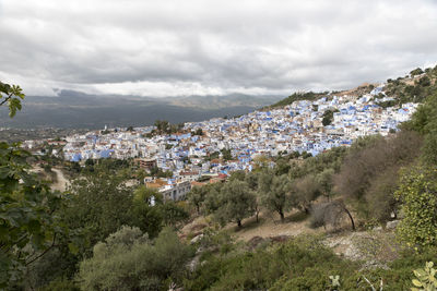 Aerial view of townscape and mountains against sky