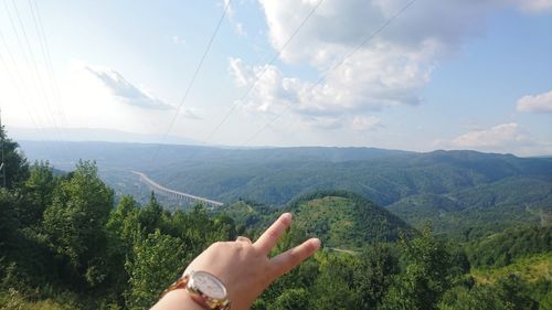 Midsection of woman against mountain range against sky