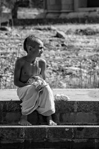 Side view of kid while sitting on staircase