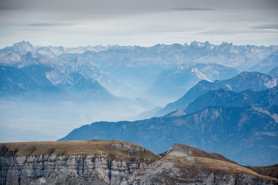 Scenic view of snowcapped mountains against cloudy sky