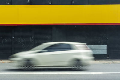 Blurred motion of yellow car on road