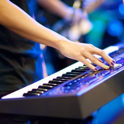 Close-up of hand playing piano