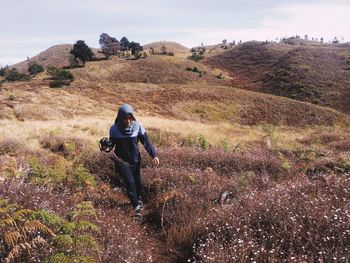 Rear view of woman on mountain against sky