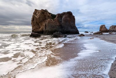 Rocks on beach against sky