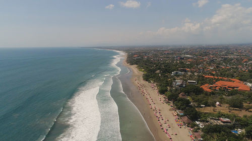 Aerial view sand beach with resting people, hotels and tourists, sun umbrellas, bali, kuta. 