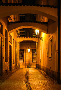 Illuminated street amidst buildings at night