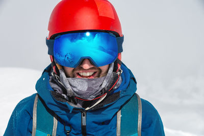 Close up of the ski goggles of a man with the reflection of snowed mountains. a mountain range