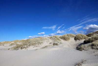 Scenic view of desert against blue sky