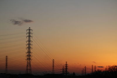 Silhouette electricity pylon against sky during sunset