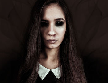 Portrait of spooky woman standing in darkroom