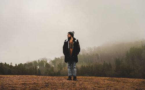 Woman standing on field against sky