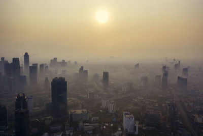 Aerial view of city buildings against sky during sunset