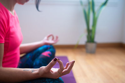 Midsection of woman using mobile phone while sitting on table