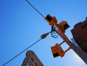 Low angle view of road signal against clear blue sky