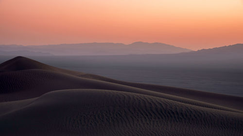 Scenic view of desert against sky during sunset