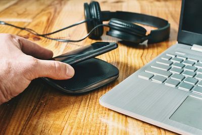 Cropped hands using laptop on table