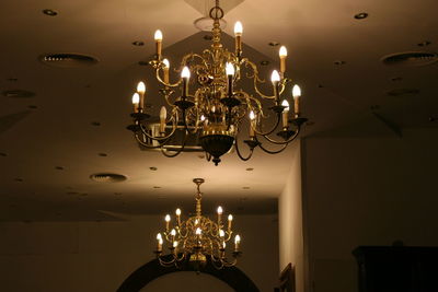 Low angle view of illuminated light bulb hanging at home