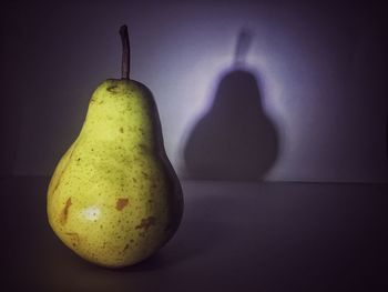 Close-up of pear with shadow on wall