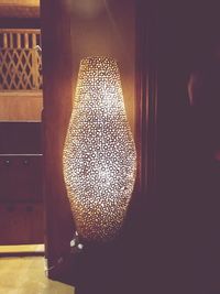 Close-up of illuminated lamp on table