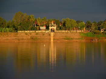 Scenic view of lake by building against sky