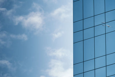 Low angle view of modern glass building against sky