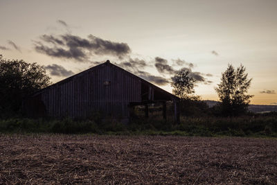 Abandoned barn on field against sky