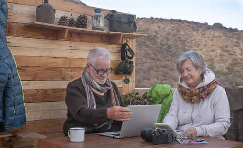 Woman using phone while sitting on table