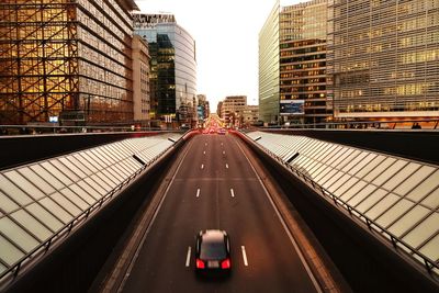 Vehicles on road amidst buildings in city