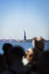 Rear view of woman looking at sea against clear sky