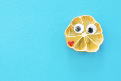 High angle view of lemon slice against blue background