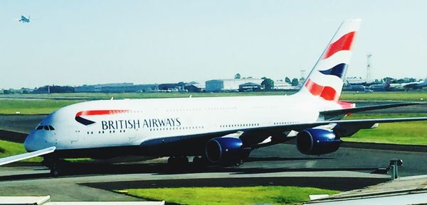 Airplane on airport runway against clear sky