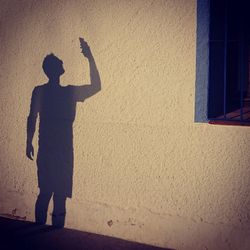 Rear view of silhouette man standing against wall