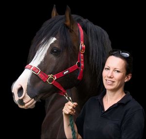 Portrait of woman with horse against black background