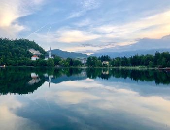 Scenic view of lake by trees against sky