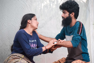 Young couple sitting in traditional clothing standing outdoors